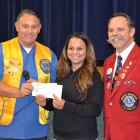 Janet Perez, form Hanford Boxing Club, accepts a check from Kings Lions President Roman Benitez and District Governor Al Kroell.